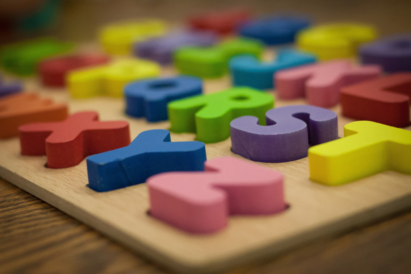 Buntes Buchstaben-Steckpuzzle aus Holz mit einzelnen Formen zum Einsetzen